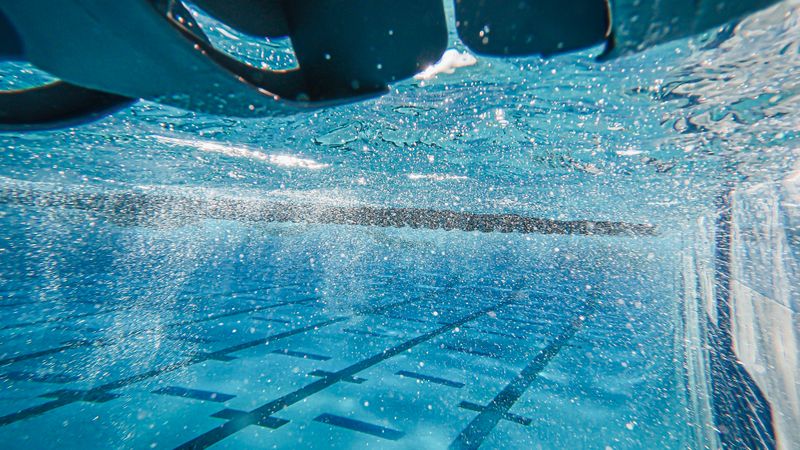 Robot de piscine posé sur la margelle d'un bassin avant sa mise à l'eau