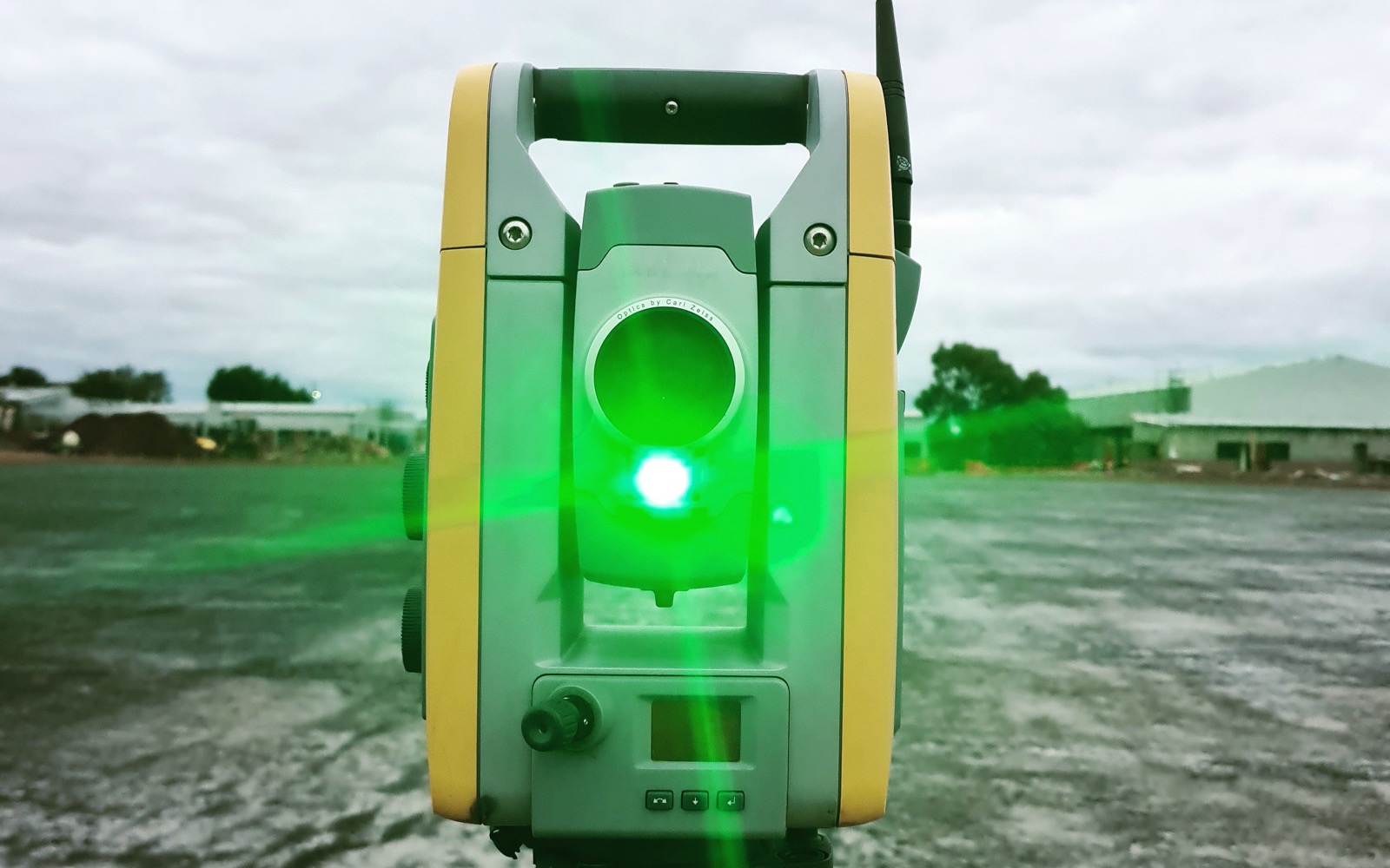 station totale de géomètre utilisée sur un terrain en chantier, visée laser verte