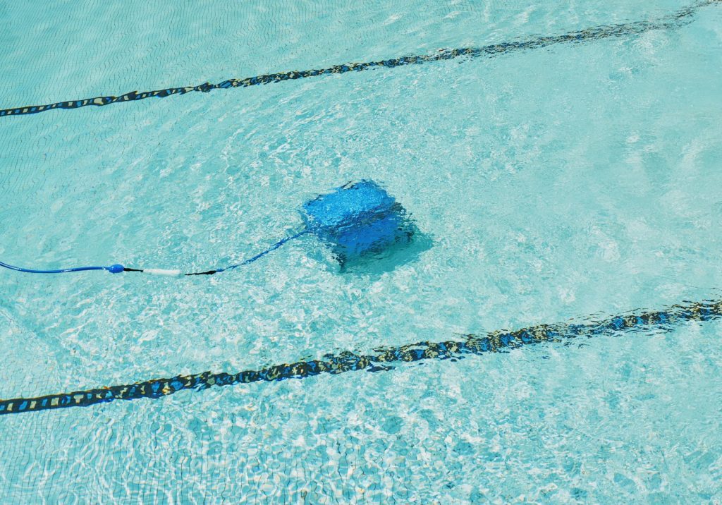 Robot de piscine électrique filaire en train de nettoyer le fond du bassin