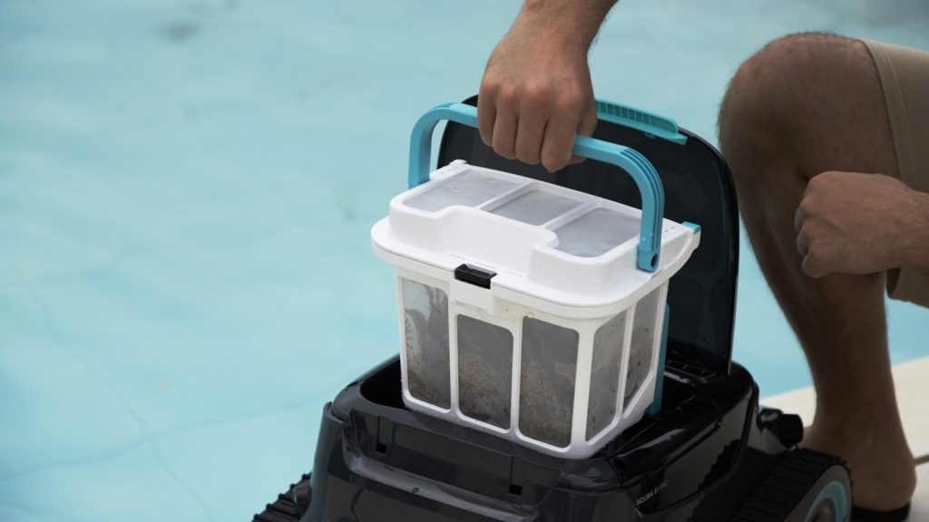 Vidage du panier filtrant d'un robot de piscine au bord du bassin