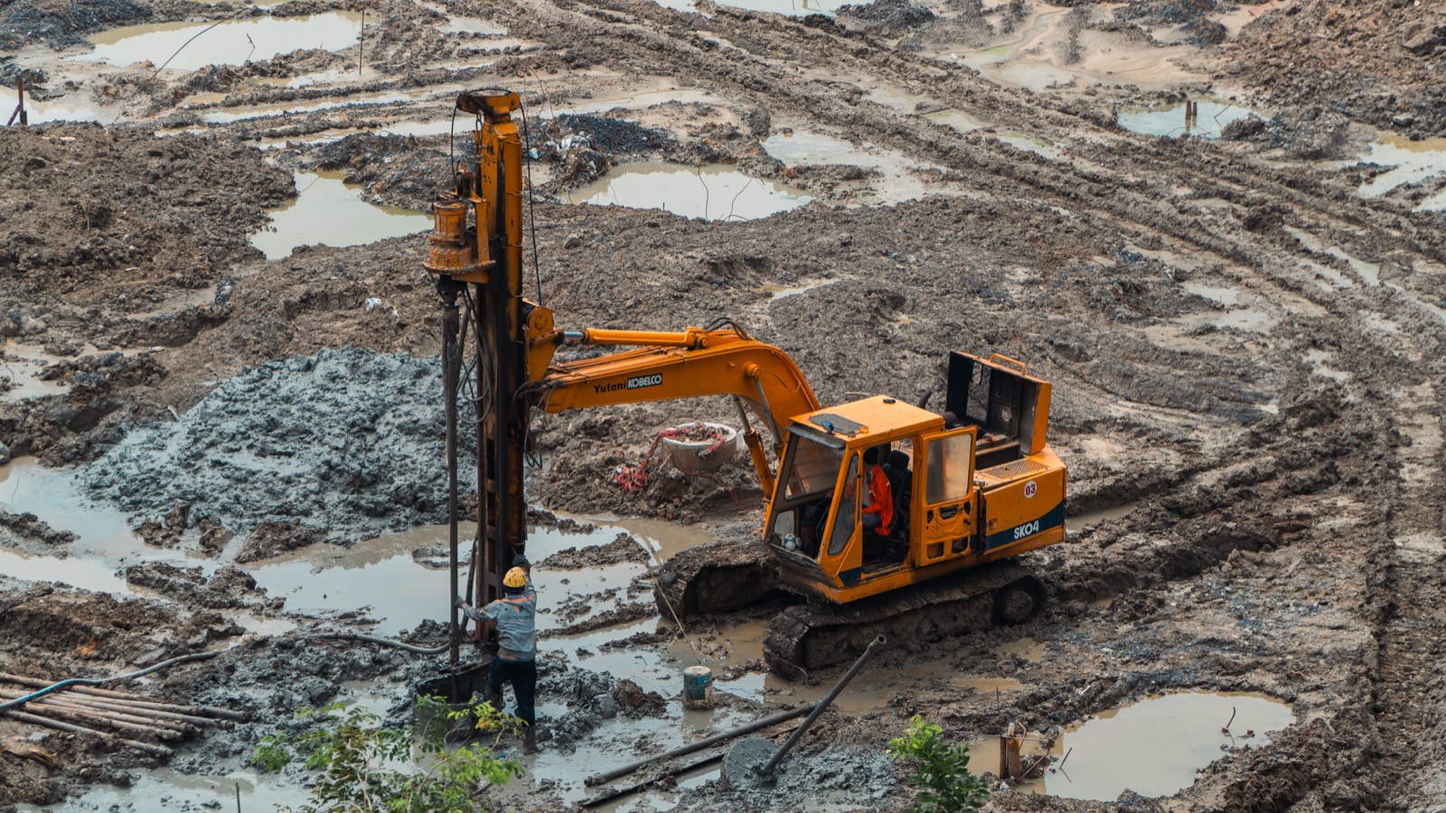 Pelleteuse creusant le bassin d'une future piscine sur un terrain en pente